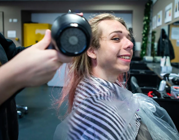 Smiling client getting their hair blow-dried in a salon. Smiling client getting their hair blow-dried in a salon.